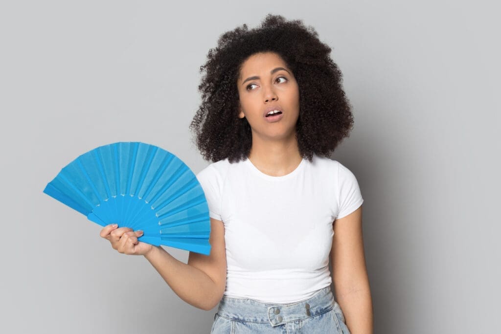 Overheated biracial girl using hand waver cooling herself - Local SEO and Search Engine Marketing | FMS Online Marketing woman with a fan