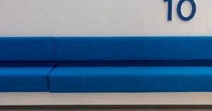 Blue cushioned bench seating along a white wall with the number 10 visible on the wall.